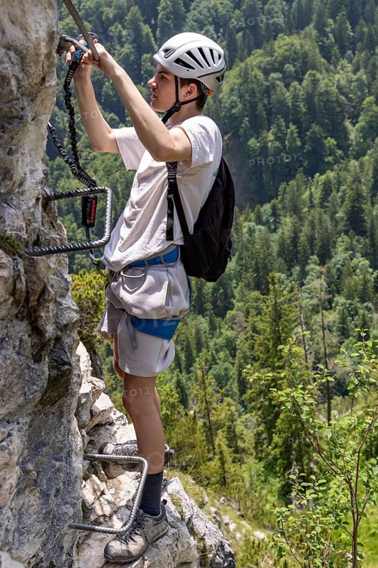 Mountaineer climbing over a steep ladder in the Isidor via ferrata, GrÃ¼nstein, Schönau am Königssee, Berchtesgadener Land, Upper Bavaria, Bavaria, Germany