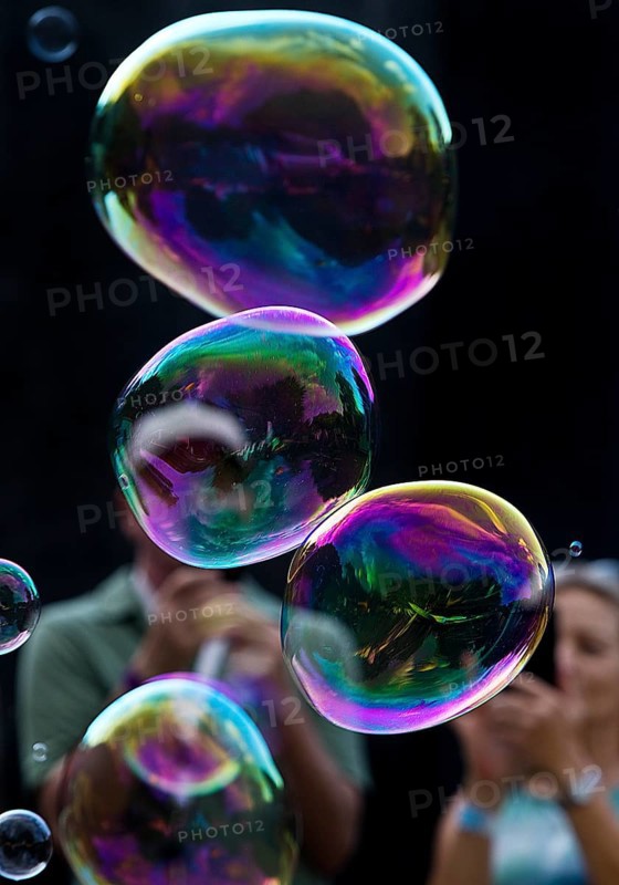 A man and a woman photograph iridescent soap bubbles in front of a black background, Recklinghausen, North Rhine-Westphalia, Germany