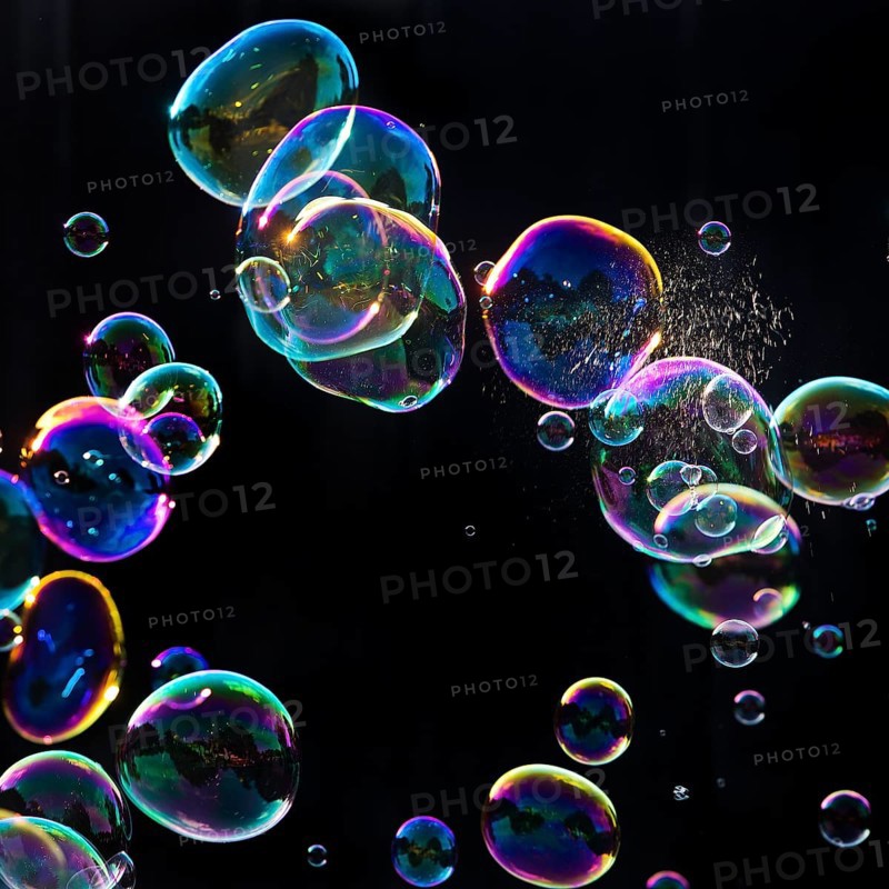 Iridescent soap bubbles with a just burst bubble in front of a black background, Recklinghausen, North Rhine-Westphalia, Germany