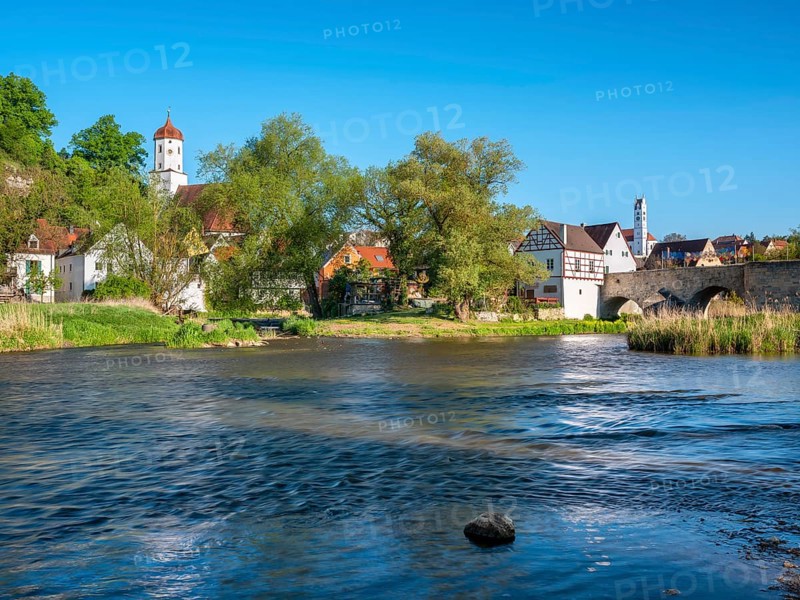 View over the river Wörnitz to the old town with the Stone Bridge and the churches of St Barbara and Herz Jesu, Harburg, Donau-Ries, Swabia, Bavaria, Germany