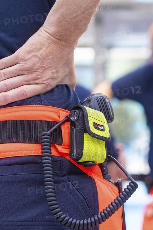 Close-up of fire brigade equipment with radio and firefighter in uniform, fire brigade exercise for gondola rescue, Germany