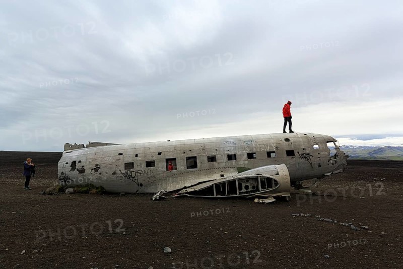Tourist on aircraft wreckage, US Navy Douglas DC-3 transport plane, Sander, volcanic landscape, SÃ³lheimasandur, Solheimasandur, near ring road, SuÃ°urland, Sudurland, South Iceland, Iceland