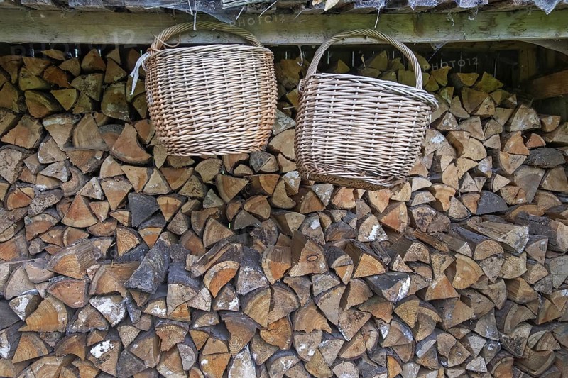 Two baskets hanging in front of a pile of wood, Germany