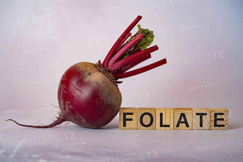 Crimson beetroot with wooden blocks spelling Folate. Studio composition showcasing natural nutrients and root vegetable texture. Generative ai, AI generated