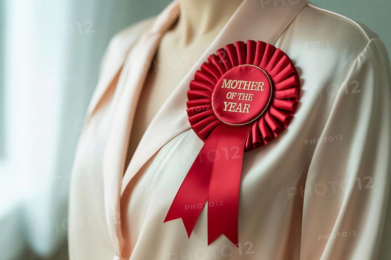 Red award rosette ribbon with text Mother of the year pinned to woman's blouse. Concept of motherhood appreciation and recognition. Generative ai, AI generated