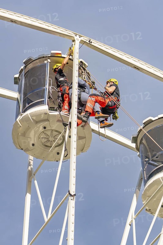 Two workers in protective clothing carry out inspections on a Ferris wheel, fire brigade exercise for gondola rescue, Germany