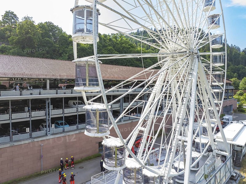 View of a Ferris wheel in a city, firefighters on site, fire brigade exercise for gondola rescue, Germany