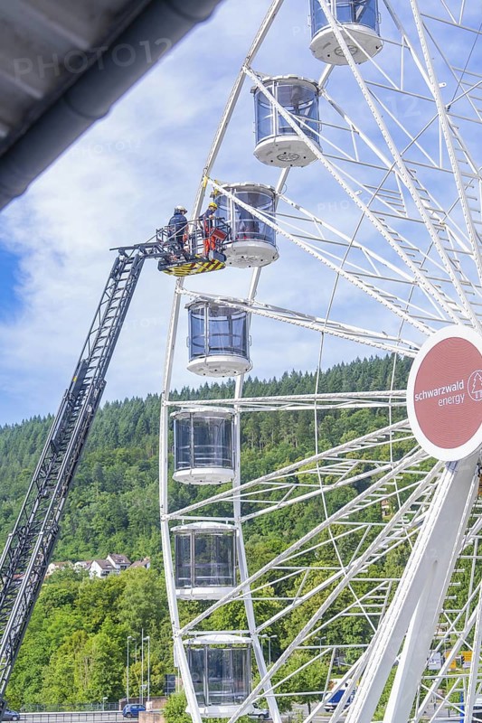 Firefighters carry out a rescue operation in a Ferris wheel standing in a green environment, Fire brigade exercise for gondola rescue Ferris wheel, Calw, Germany