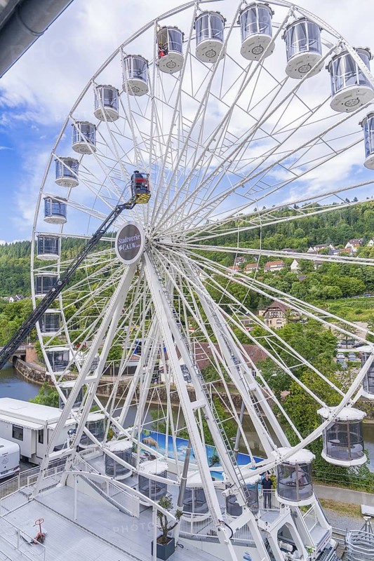Large Ferris wheel with a view of a green landscape and houses in the background, fire brigade exercise for gondola rescue Ferris wheel, Calw, Germany