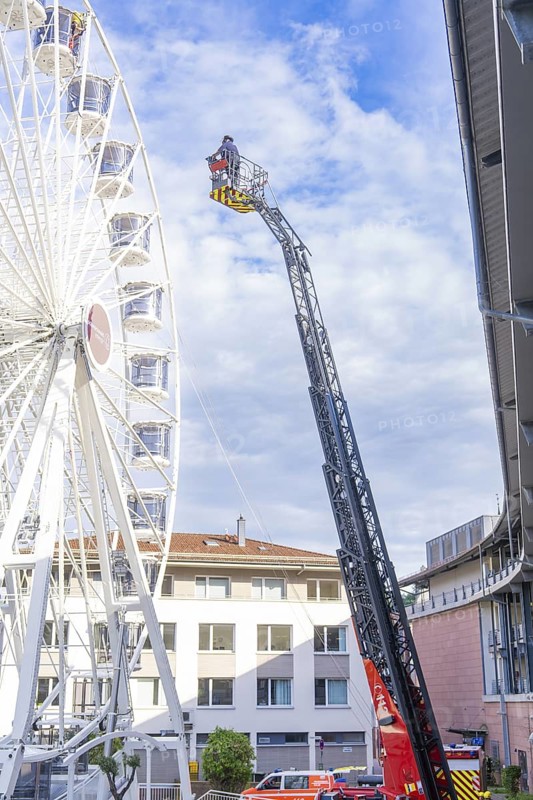 Fire brigade ladder next to a building front with operating platform in use, fire brigade exercise for gondola rescue Ferris wheel, Calw, Germany