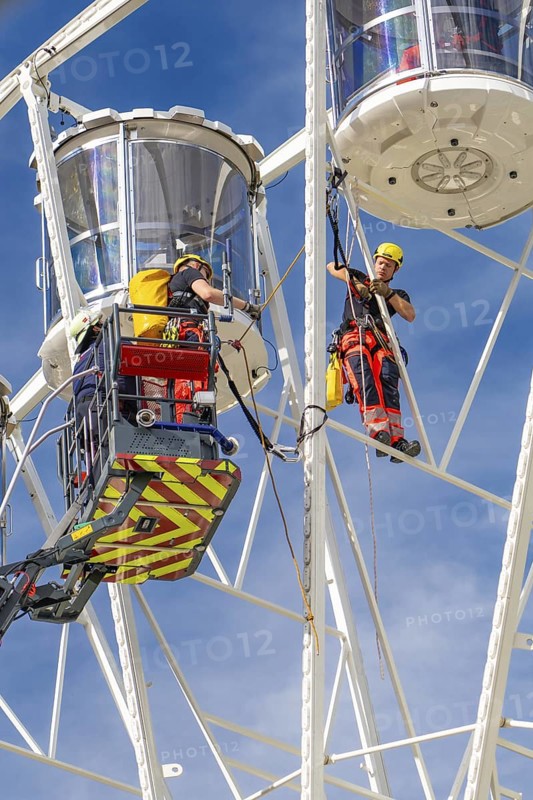 Worker with safety equipment during maintenance work on a Ferris wheel, fire brigade exercise for gondola rescue Ferris wheel, Calw, Germany
