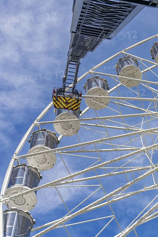 Fire brigade ladder extends against the sky to the cabins of the Ferris wheel, ready for a rescue, Fire brigade exercise for gondola rescue Ferris wheel, Calw, Germany