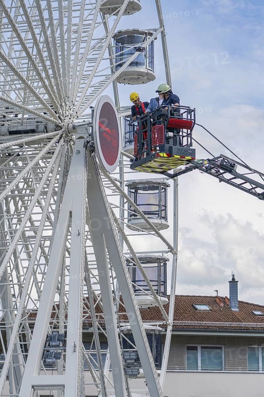 Firefighters in the rescue cage near the Ferris wheel, a building is visible in the background, fire brigade exercise for gondola rescue Ferris wheel, Calw, Germany