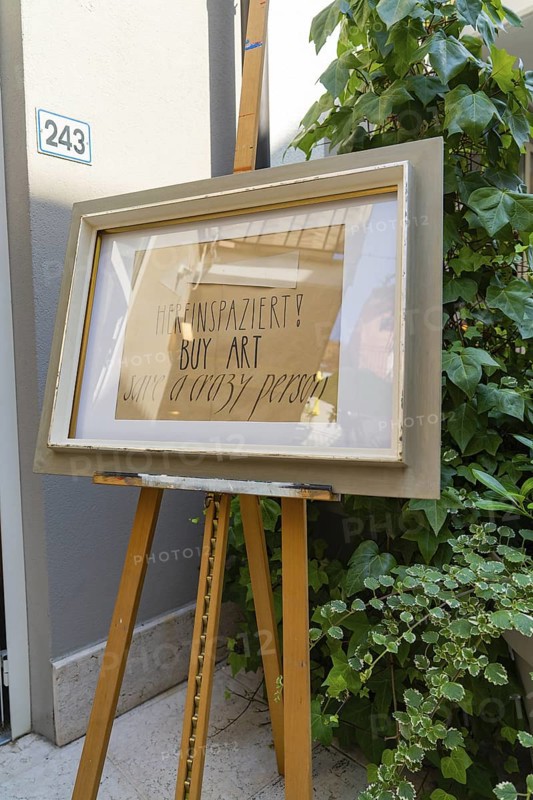 Artwork on easel next to a plant in front of a grey wall, Merano, South Tyrol, Italy