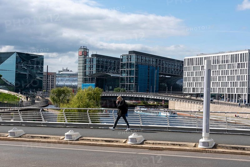 Modern city view with glass buildings, bridge and river under a cloudy sky, Berlin Central Station, Berlin, Germany