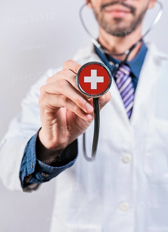 Female doctor holding stethoscope with Switzerland flag. National health system of Switzerland