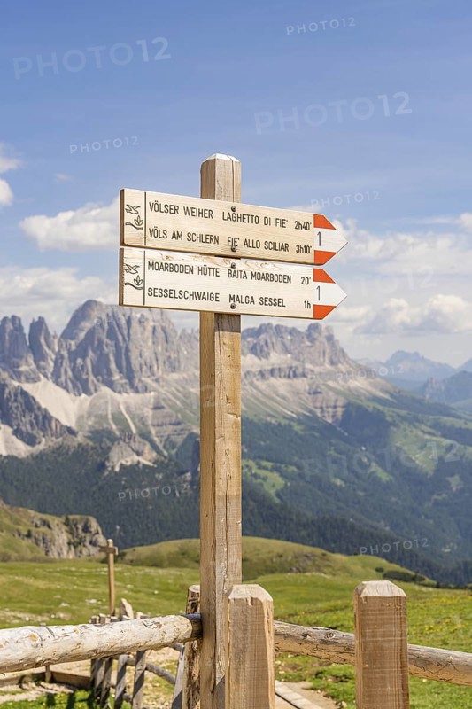 A wooden signpost points the way, the majestic mountains in the background, hike to the Schlehrn, Seiser Alm, Dolomites, South Tyrol, Italy