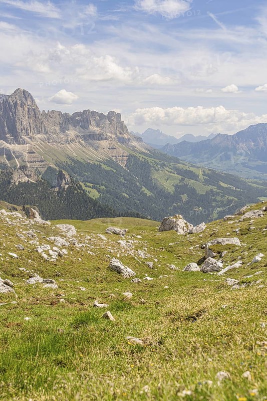 Green hills and mountains under a blue sky with soft clouds, hike to the Schlehrn, Alpe di Siusi, Dolomites, South Tyrol, Italy