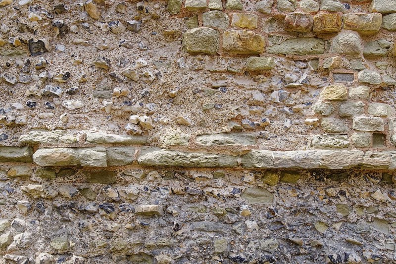 Masonry of the historic castle wall of Pevensey Castle, a Norman castle, in the village of Pevensey, Sussex, England, Great Britain