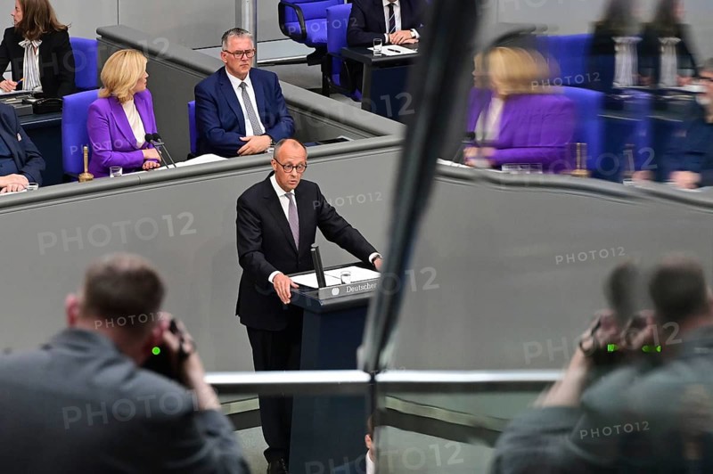 Federal Chancellor Friedrich Merz (CDU) during his government statement today. A photographer takes pictures from the press gallery