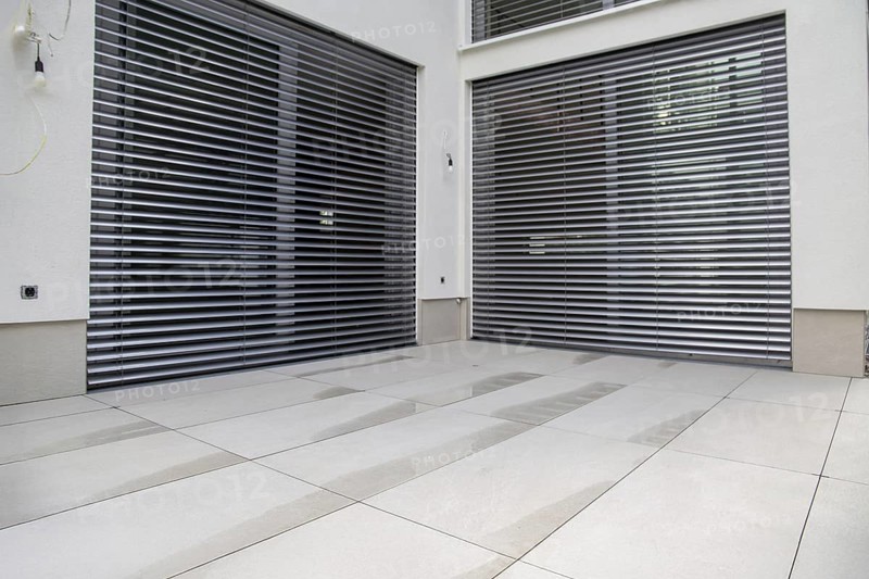 Modern terrace with large, light-coloured terrace tiles on a new detached house