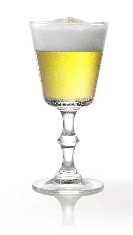 Cocktail with head of foam in a pointed goblet style glass in front of a white background, studio shot