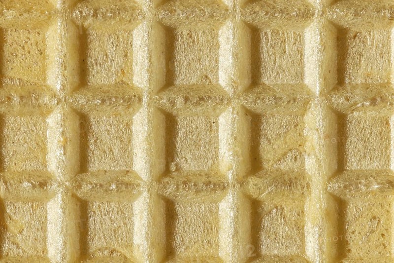 Beige, grid-like texture of a crispy wafer, macro image