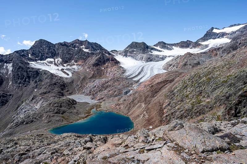 Blue glacial lake in a rocky mountain landscape, behind Königshofspitz and Ãœbeltalferner glacier, descent from the summit of Roter Grat, Stubai Alps, South Tyrol, Italy