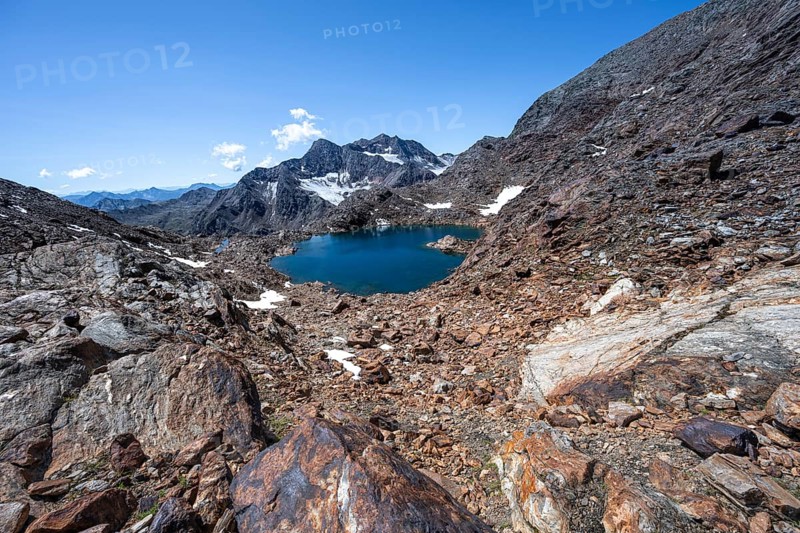 Blue glacial lake in a rocky mountain landscape, Königshofspitz in the background, descent from the summit of the Roter Grat, Stubai Alps, South Tyrol, Italy