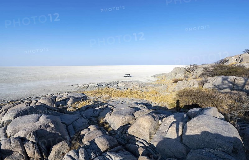 Round rocks of Kubu Island with view over the salt pan, off-road vehicle on the salt pan, Kubu Island (Lekubu), Sowa Pan, Makgadikgadi Salt Pans, Botswana
