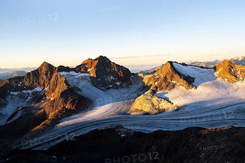 Picturesque high mountain landscape at sunrise with alpenglow, glacier and rocky mountain peaks in the morning light, view of the Königshofspitz mountain peak and Ãœbeltalferner glacier, Stubai Alps, South Tyrol, Italy