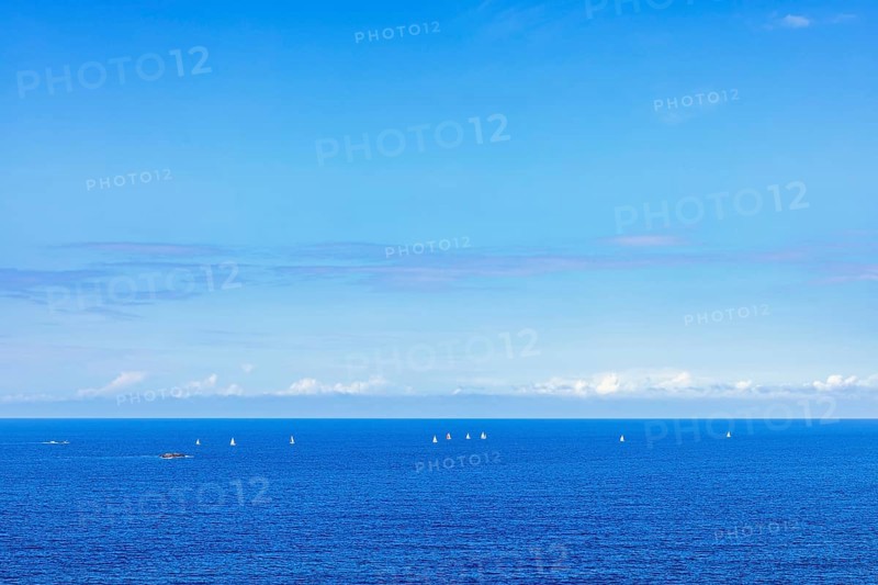 Sea view towards the horizon with sailboats sailing on the blue sea a sunny summer day, Crozon Peninsula, Bretagne, France