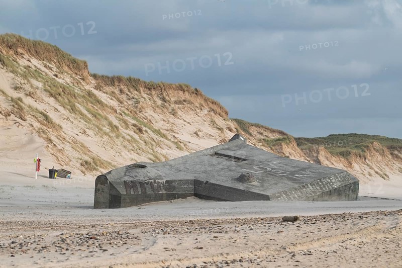 Abandoned bunker from the 2nd World War, sunken into the sand with graffiti, surrounded by sand dunes, beach near Hvide Sande, North Sea, Denmark