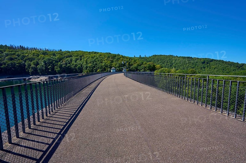 Straight view of an asphalted bridge with railing over a dam, summer, Urft dam wall, Obersee, Urftsee, Schleiden, Eifel National Park, Eifel, North Rhine-Westphalia, Germany
