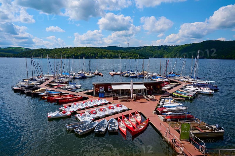 Pedal boats and other boats are moored on a jetty in a large lake and offer leisure activities, summer, Rursee, Rurtalsperre, Heimbach, Simmerath, Eifel National Park, North Rhine-Westphalia, Germany