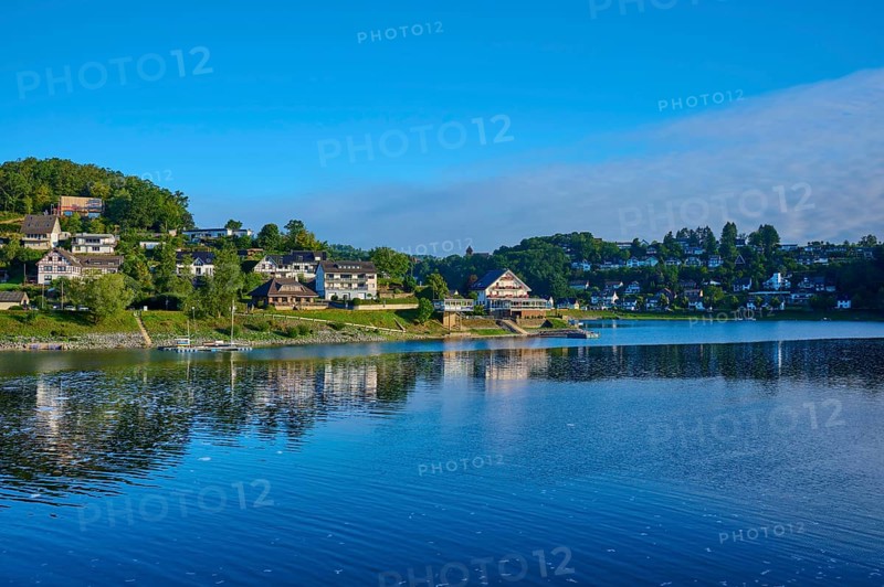 Idyllic lake with houses on the shore, clear blue sky on a sunny summer day, summer, Rursee, Rurberg, Simmerath, Eifel National Park, North Rhine-Westphalia, Germany