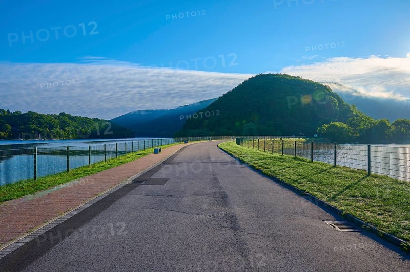 Paulushof barrier dam, dam road along a lake in a mountainous landscape, morning light and clear sky, summer, Rursee, Obersee, Rurberg, Simmerath, Eifel National Park, North Rhine-Westphalia, Germany