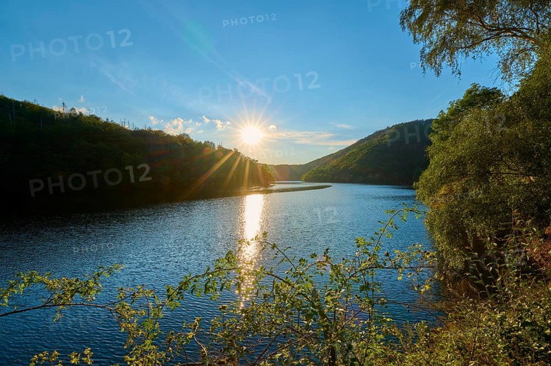Sunset reflected in the lake, surrounded by forest and hills, summer, Rursee, Obersee, Simmerath, Eifel National Park, North Rhine-Westphalia, Germany