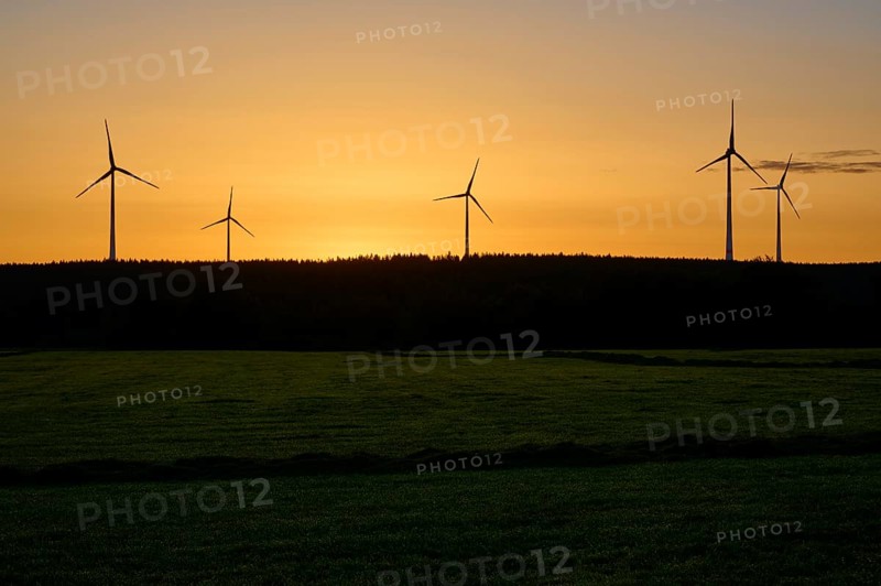 Silhouette of wind turbines at sunrise, over a green field, summer, Rohren, Monschau, Eifel, North Rhine-Westphalia, Germany