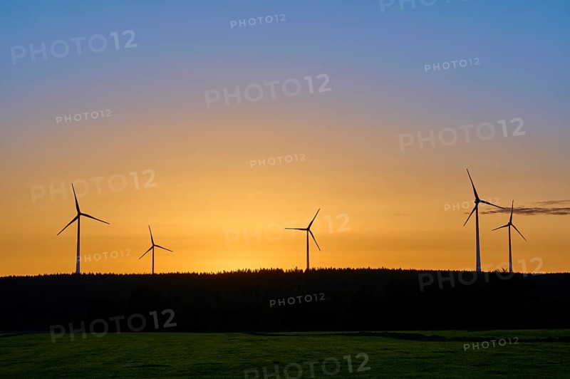 Wind turbines in front of an orange-coloured sky at sunrise, above a meadow, summer, Rohren, Monschau, Eifel, North Rhine-Westphalia, Germany