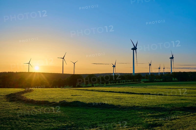 Series of wind turbines at sunrise, play of lights on a green meadow, summer, Rohren, Monschau, Eifel, North Rhine-Westphalia, Germany