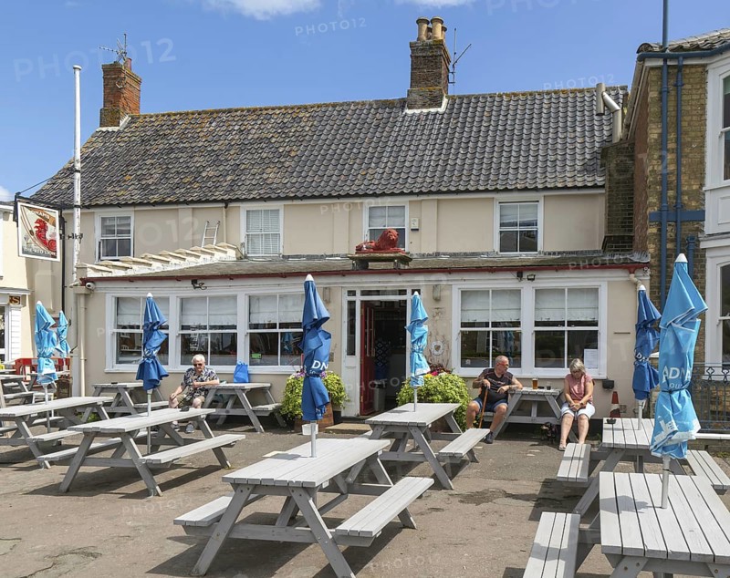 People sitting outside the Red Lion pub, Southwold, Suffolk, England, UK