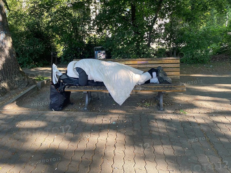 Homeless man sleeping on a park bench in Viktoriapark, District Friedrichshain-Kreuzberg, Social issue, Poverty, Homelessness