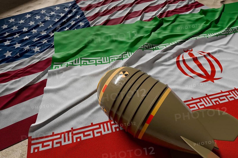 Nuclear bomb, american and Iranian flags resting on desert sand