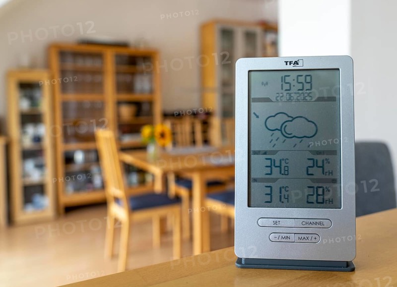 Summer heat, digital thermometer in an attic flat, city centre, outside temperature in the afternoon over 34Â°C, in the flat 31Â°C, flat without air conditioning, heats up a lot, health risk, symbolic image climate change