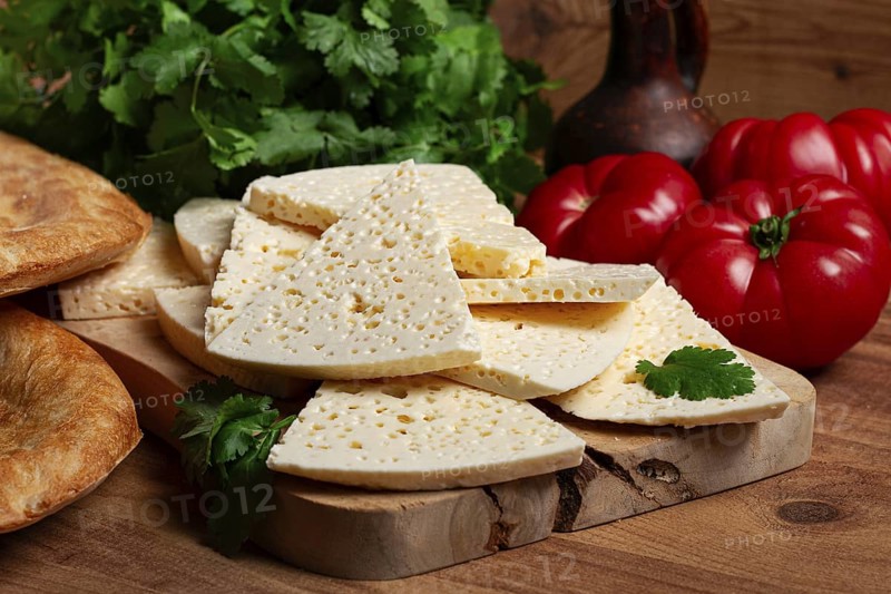 Georgian sliced cheese, on a wooden chopping board, with tomatoes with herbs and lavash, rustic style, Georgian cuisine, no people