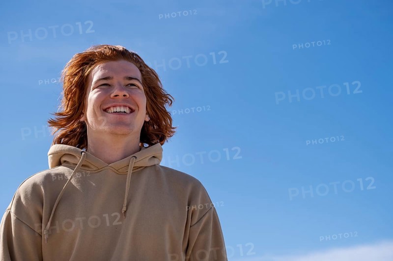 Young man red-haired, laughing, against blue sky, Jeffreys Bay near Port Elizabeth, Garden Route, Eastern Cape, South Africa