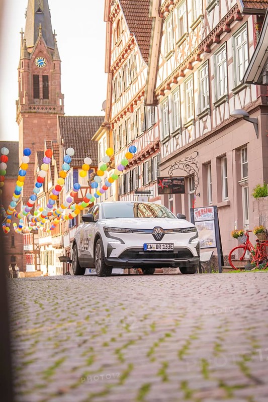 A car on a cobbled street with half-timbered houses and balloons, Deer E, car sharing, electric car, Calw, Black Forest