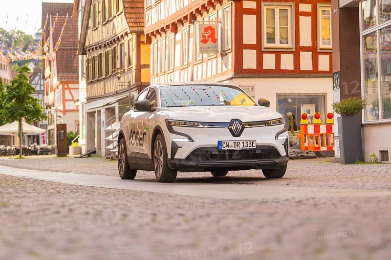 A Renault in a city street with half-timbered houses and shop windows, Deer E, car sharing, electric car, Calw, Black Forest