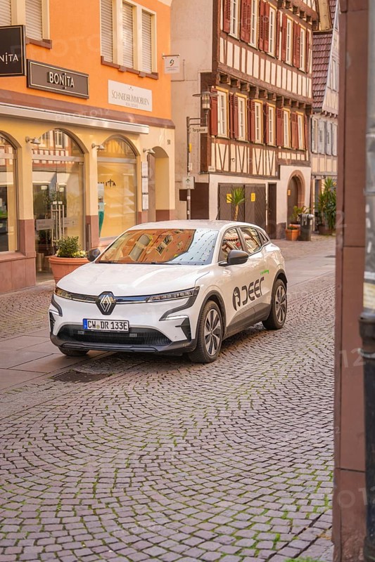 An electric car in front of half-timbered houses in a historic shopping street, Deer E, car sharing, electric car, Calw, Black Forest